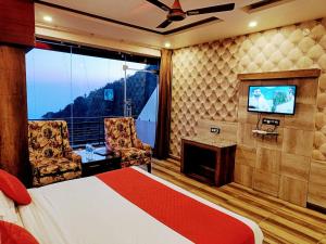 a hotel room with a bed and a tv at Hotel The King near mall rd mcleodganj in Dharmsāla