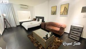 een woonkamer met een bank, een bed en een tafel bij A In Hotel Glamour in Ho Chi Minh-stad