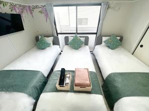 a small room with two beds and a tv at 江元浅草 in Tokyo