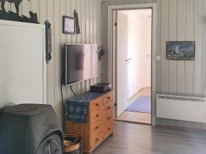 a room with a television on a dresser and a door at Two-Bedroom Holiday home in Storfosna in Sletta