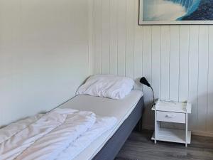 ein Schlafzimmer mit einem Bett und einem Nachttisch mit einer Lampe in der Unterkunft Two-Bedroom Holiday home in Storfosna in Sletta