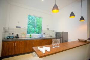 a kitchen with a wooden counter with glasses on it at Villa Nine84 Mirissa in Matara