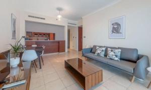 a living room with a couch and a table at Manzil - 1BR in Fairways West with Golf Course View in Dubai