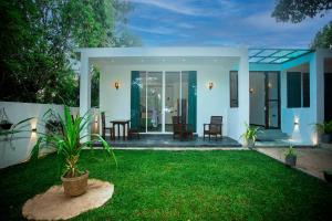 a house with a green lawn in front of it at Villa Nine84 Mirissa in Matara