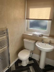 baño con aseo y lavabo y ventana en 3 bed, entire house sleeps 6 ideal for tradesmen A, en Airdrie