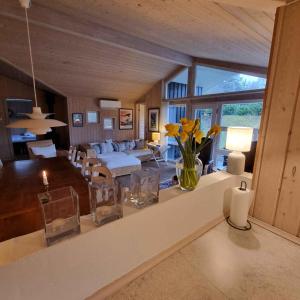 uma sala de estar com um sofá e uma mesa com flores em Excellent Cottage With Sauna And Spa, 10 Persons, em Højby