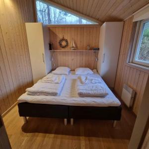 uma cama num pequeno quarto com uma janela em Excellent Cottage With Sauna And Spa, 10 Persons, em Højby