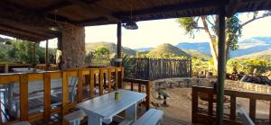 a porch with a table and chairs and mountains at Koedoeskloof Guesthouse in Ladismith