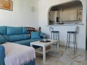 - un salon avec un canapé bleu et une table dans l'établissement Apartamento Sunbeach, à Torremolinos