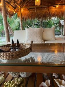 a couch sitting on a table in a straw umbrella at Leleu Mentawai Accommodation in Tua Pejat