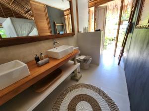 Baño con 2 lavabos y espejo en Leleu Mentawai Accommodation, en Tua Pejat