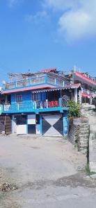 ein blaues Gebäude mit Balkon darüber in der Unterkunft Shriya Homestay in Kurseong
