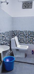 y baño con aseo blanco y lavamanos. en Shriya Homestay en Kurseong