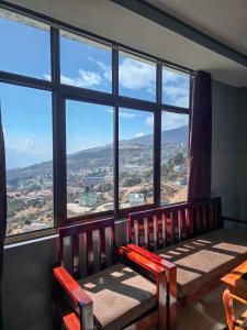a room with a bench and a large window at Hotel Kimnas in Tawang