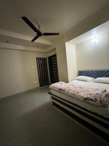 Schlafzimmer mit einem Bett und einem Deckenventilator in der Unterkunft Sovereign Sanctuary in Guwahati