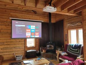 a living room with a large screen in a log cabin at Doty's River Inn is a Peaceful 3bd in Twin Lakes in Twin Lakes +19 photos