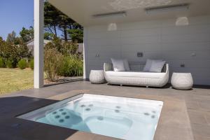 una vasca idromassaggio seduta su un patio con divano di Seaside Sanctuary - Pool and Beachfront a Ventnor