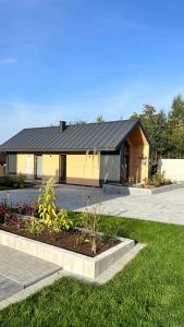 una casa con techo negro y jardín en DOMKI NA LUZIE, en Spytkowice