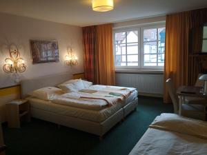 コルバッハにあるHotel Goldflair am Rathausのベッド2台と窓が備わるホテルルームです。