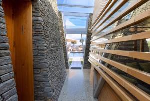 a hallway of a house with a stone wall at Kina Retreat - Luxury Nelson Getaway in Tasman