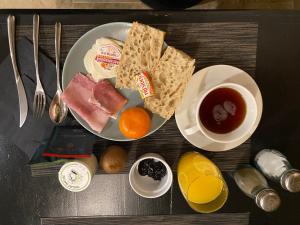 uma mesa com um prato de comida para o pequeno-almoço e uma chávena de café em La tête dans les nuages em Le Fel