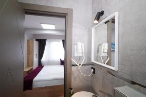 ein Hotelzimmer mit einem Bett und einem Spiegel in der Unterkunft Meet İstanbul Hotel Kadikoy in Istanbul