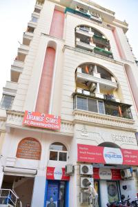 a tall white building with red signs on it at Orange Stays in Varanasi