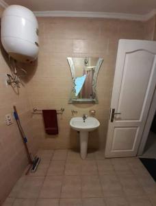 a bathroom with a sink and a mirror and a door at Studio with pool view at Bella Vista resort sokhna in Ain Sokhna