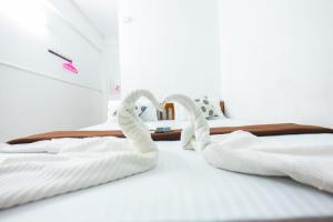 Dos cisnes hechos de toallas en una cama en SIYA RESIDENCY en Ernakulam