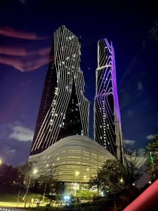 dos edificios altos se iluminan por la noche en Simple Mont Kiara, 1B1B, 4.5 Pax, Mitec Matrade en Kuala Lumpur