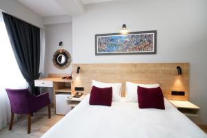 um quarto com uma grande cama branca com almofadas vermelhas em Meet İstanbul Hotel Kadikoy em Istambul