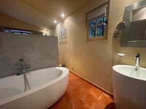 La salle de bains est pourvue d'une grande baignoire et d'un lavabo. dans l'établissement Mas de Provence en Riviera, à La Roquette-sur-Var