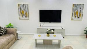 ein Wohnzimmer mit einem TV und einem Couchtisch in der Unterkunft Family Apt With New Ac in Amman