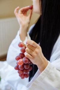 una mujer está sosteniendo un montón de uvas en Villa Kvitka en Svalyava