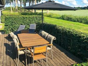 una mesa de madera y sillas con sombrilla en 8 person holiday home in Bogense, en Bogense