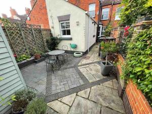 a small patio with a table and some plants at Elegant, quirky home in up-and-coming Wolverton in Wolverton