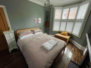 een slaapkamer met een bed en een kroonluchter bij Elegant, quirky home in up-and-coming Wolverton in Wolverton