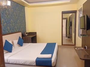 a hotel room with a bed and a television at Hotel Janki International Sigra 2 KM From Kashi Vishwanath Temple in Varanasi