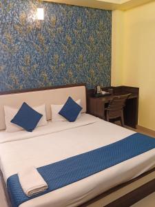 een slaapkamer met een bed, een bureau en een tafel bij Hotel Janki International Sigra 2 KM From Kashi Vishwanath Temple in Varanasi