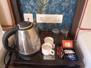a tea kettle on a tray next to a bed at Hotel Janki International Sigra 2 KM From Kashi Vishwanath Temple in Varanasi