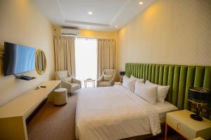 a hotel room with a large bed with a green headboard at Devon Rest in Kandy