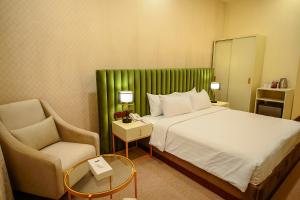 Habitación de hotel con cama y silla en Devon Rest, en Kandy
