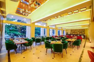 uma sala de jantar com mesas e cadeiras verdes em Devon Rest em Kandy