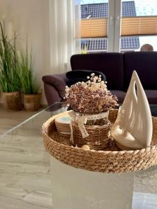 a coffee table with a basket and shoes on it at Ferienwohnung Joanna in Norddeich