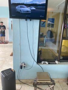 a tv on a wall with a car on the screen at Main Stream Beach Villa in Senga