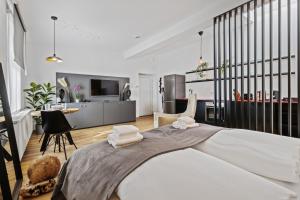 a bedroom with a large bed and a kitchen at Stylish Tiny City House in Augsburg