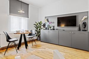 een woonkamer met een tafel en een televisie bij Stylish Tiny City House in Augsburg