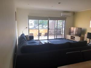 uma sala de estar com um sofá e uma televisão em Mahogany Motel Warrnambool em Warrnambool