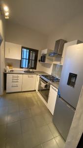 uma cozinha com armários brancos e um frigorífico em Villa à Lomé em Lomé