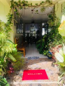 a welcome sign in the middle of a room with plants at D's Oceanview Beach Resort in Siquijor